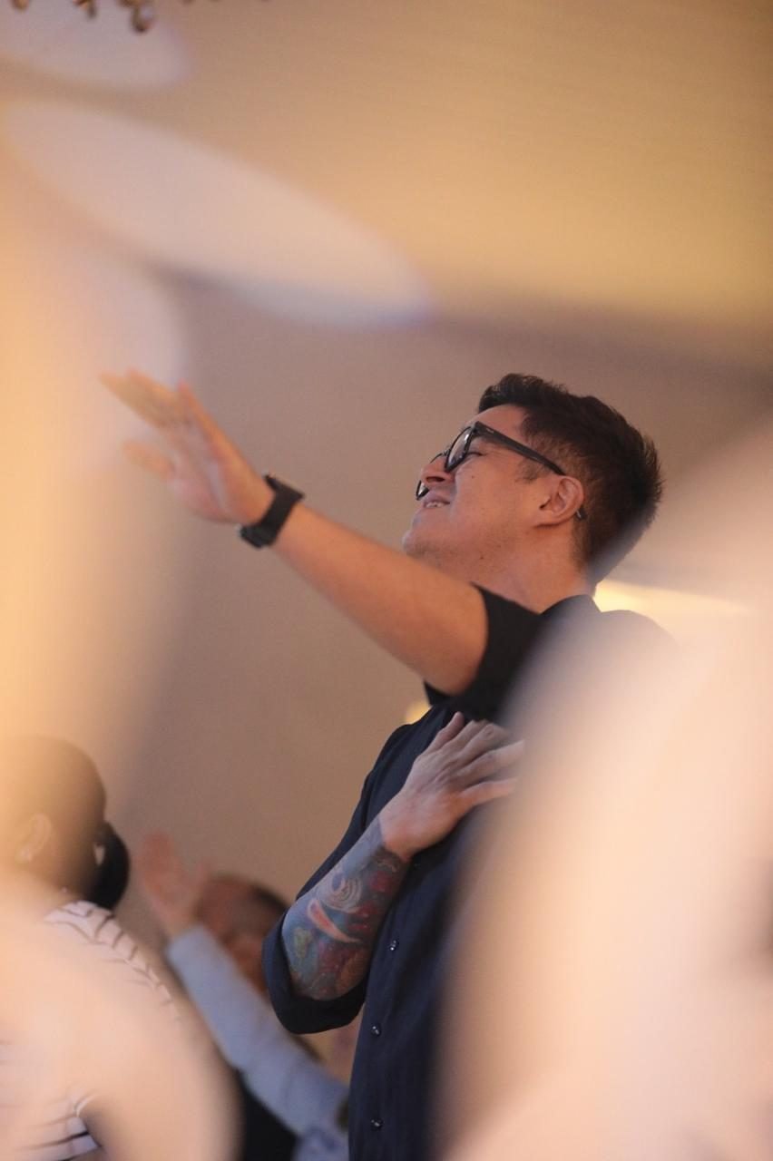 Pessoa em oração com a mão no peito durante o culto